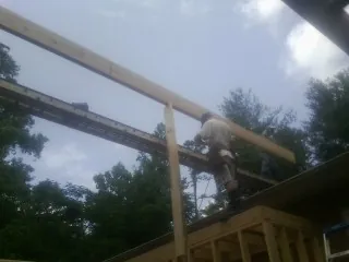 Carpenter setting a ridge beam over a new addition frame — Ice Dam Removal by Roofing Brothers in Burnettsville