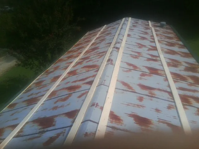 Rusted metal roof panels with new wood purlins before replacement — Storm Damage Roof Repair in Burnettsville by Roofing Brothers