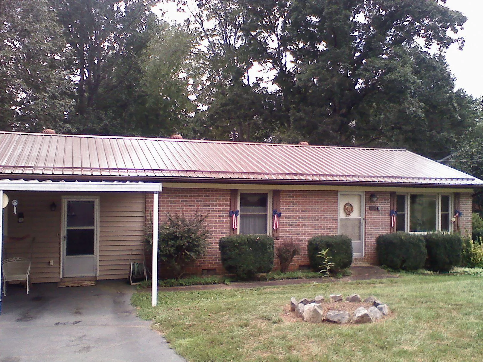Bronze metal roof and carport on a brick ranch home — Roof Repair work by our crew in Burnettsville