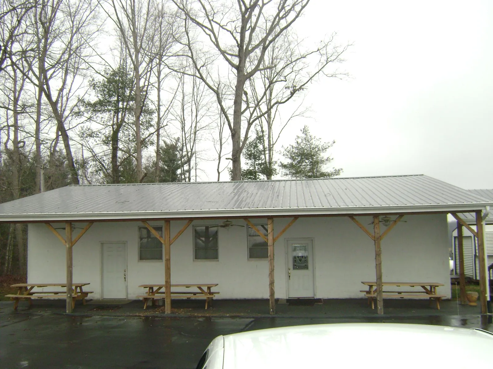 Gray metal roof over a block building with a timber post porch in Burnettsville